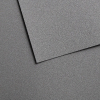 Close-up of dark gray textured foam panels overlapping at angle lines on a speckled surface.