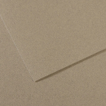 Two overlapping sheets of brown kraft cardboard on a light tan surface (close-up).