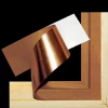 Copper leaf being applied to a wooden picture frame against a black background.