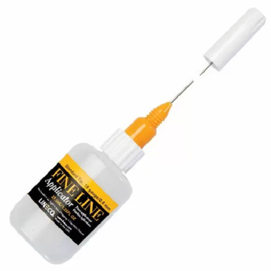 White precision applicator bottle with orange tip and long needle attached, used for fine-line liquid application.